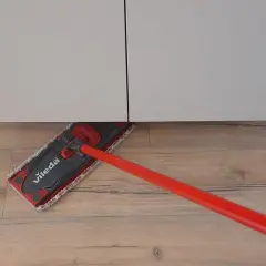 Mocio Vileda pulisce il laminato effetto legno sotto un mobile bianco.
